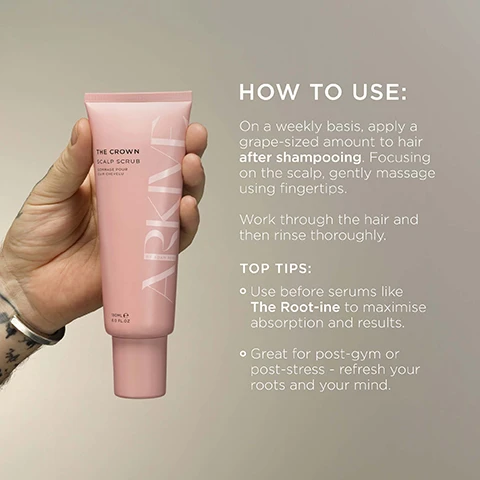Image 3 - A hand holds a pink tube of Arkive The Crown Scalp Scrub, 180ml / 6.0 fl.oz, next to text that reads HOW TO USE: On a weekly basis, apply a grape-sized amount to hair after shampooing. Focusing on the scalp, gently massage using fingertips. Work through the hair and then rinse thoroughly. TOP TIPS: Use before serums like The Root-ine to maximise absorption and results. Great for post-gym or post-stress - refresh your roots and your mind. Image 4 - A hand with dark fingernails and a gold chain bracelet holds a light pink tube of ARKIVE The Crown Scalp Scrub against a reflective surface with smudges, while overlaying text states Pineapple Enzymes help dissolve dead skin for a fresh, balanced scalp, Baobab Oil helps to soften & moisturise the scalp, and Plant-Based Exfoliator to gently lift away flakes & residue. Image 6 - A close-up of a branch with small white flowers and green leaves in the foreground, with blurred hints of an orange fruit and a light-colored cylindrical object in the background, accompanying text that reads: SMELLS LIKE: FUTURE BLOOM. A genderful floral fragrance that emulates a sun-soaked summer walk: liberating, luminous and full of potential. HEAD NOTES MANDARIN RHUBARB. HEART NOTES JASMINE LILY OF THE VALLEY. GROUND NOTES TEA ROSE VANILLA. Image 7 - A pink tube of Arkive The Crown Scalp Scrub is placed diagonally on a patterned beige fabric with yellow and green fan motifs, alongside a light wall, displaying the text MADE WITHOUT: ALUMINIUM AMMONIA LACTOSE LATEX MINERAL OIL PARABENS, THE CROWN SCALP SCRUB GOMMAGE POUR CUIR CHEVELU, ARKIVE BY ADAM RE, 180 mL e 6.0 FL. OZ. (US), and additional labels: VEGAN, Certified B Corporation, MADE WITH RECYCLED CONTENT, Cruelty Free International, AWARD WINNING.