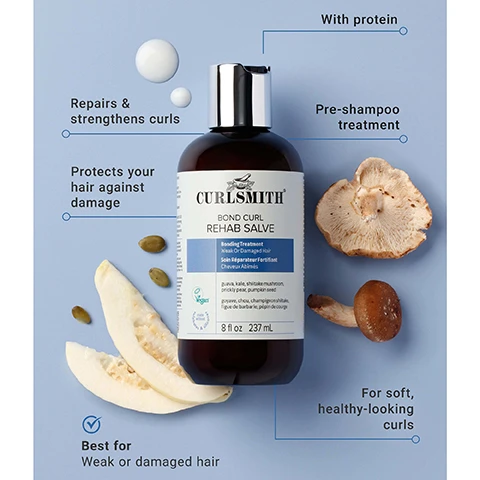 Image 1 - A dark brown bottle of Curlsmith Bond Curl Rehab Salve Bonding Treatment for Weak Or Damaged Hair with a silver cap is shown on a light blue background, surrounded by two mushrooms, two slices of light-colored fruit, and pumpkin seeds, along with text callouts: With protein, Repairs & strengthens curls, Pre-shampoo treatment, Protects your hair against damage, For soft, healthy-looking curls, Best for Weak or damaged hair, and the bottle label also reads CURLSMITH BOND CURL REHAB SALVE Bonding Treatment Weak Or Damaged Hair Soin Réparateur Fortifiant Cheveux Abimés Vegan 8 fl oz 237 mL and lists ingredients guava, kale, shiitake mushroom, prickly pear, pumpkin seed, goyave, chou, champignon shiitake, figue de barbarie, pépin de courge. Image 2 - A smiling person with brown curly hair and freckles against a blue background, with text that reads CLINICALLY PROVEN TO REDUCE DAMAGE* and visibly helps restore your hair. Image 3 - A hand dispenses white hair product from a dark brown CURLSMITH BOND CURL REHAB SALVE 8 fl oz 237 mL bottle into another hand, with text visible that states 86% said the product helped seal and reduce the appearance of split ends*. Image 4 - A brown bottle of Curlsmith Bond Curl Rehab Salve with a silver cap is shown on a blue background with decorative blue and clear curved panels and a dried mushroom, displaying the text HELPS REDUCE SPLIT ENDS* and on the bottle Curlsmith Bond Curl Rehab Salve Bonding Treatment Weak Or Damaged Hair Soin Réparateur Fortifiant Cheveux Abîmés guava, kale, shiitake mushroom, prickly pear, pumpkin seed goyave, chou, champignon shiitake, figue de barbarie, pépin de courge vegan logo 8 fl oz 237 mL. Image 5 - Two brown bottles of Curlsmith Bond Curl Rehab Salve are shown side-by-side, depicting an old packaging with a purple label on the left and a new packaging with a blue label on the right, separated by a blue arrow, against a pink and blue background, with a blue circular badge in the top right corner that reads SAME GREAT NEW LOOK PRODUCT; both bottles state CURLSMITH BOND CURL REHAB SALVE, Bonding Treatment / Soin Réparateur, Weak Or / Fortifiant, Damaged Hair / Cheveux Abîmés, 8 fl oz, 237 mL, and list ingredients including seaweed, kale, shiitake mushroom, prickly pear, and pumpkin seed; the left bottles label also explicitly features STRENGTH RECIPE / RECETTE FORTIFIANTE, WHAT’S INSIDE, and VEGAN.
